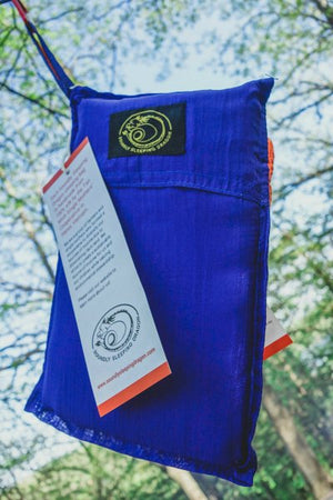 blue sleeping bag hanging from a tree